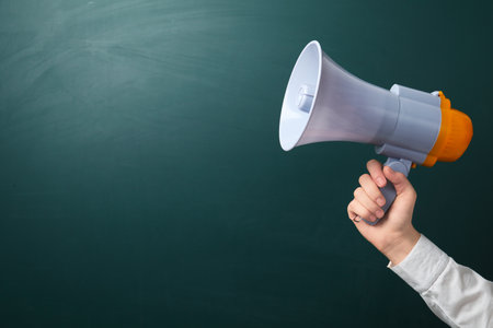 Man holding megaphone near chalkboardの写真素材