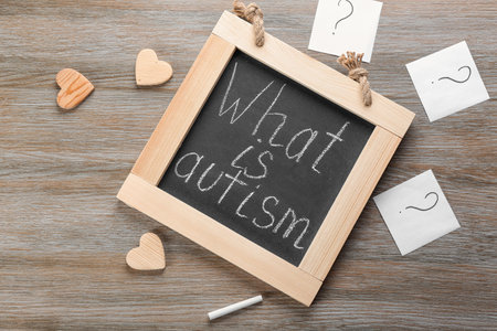 Chalkboard with phrase "What is autism?" on wooden backgroundの写真素材