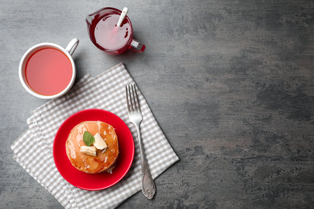 Plate with delicious pancakes and cup of tea on tableの写真素材