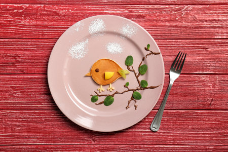 Flat lay composition with pancake in the form of bird on wooden background. creative breakfast ideas for kidsの写真素材
