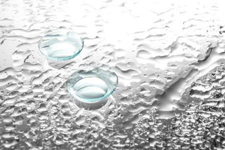 Contact lenses on wet glass backgroundの写真素材
