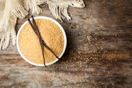 Bowl of aromatic vanilla sugar and sticks on wooden backgroundの写真素材