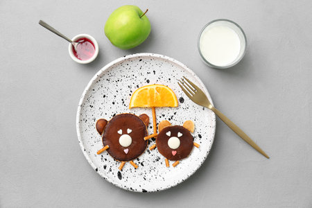Flat lay composition with funny chocolate pancakes on gray background. creative breakfast ideas for kidsの写真素材