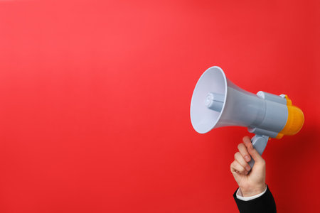Man holding megaphone on color backgroundの写真素材