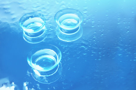 Contact lenses on color glass backgroundの写真素材