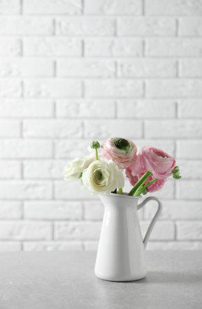 Vase with beautiful ranunculus flowers on tableの写真素材