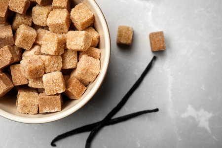 Bowl of aromatic vanilla lump sugar and sticks on gray backgroundの写真素材