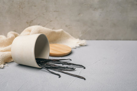 Cup with vanilla sticks on table