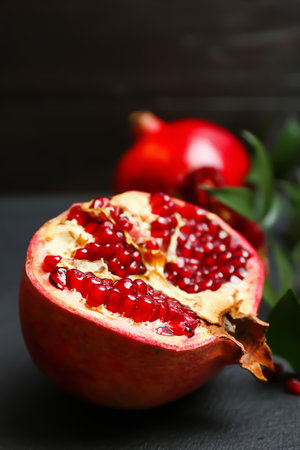 Fresh yummy pomegranate on dark tableの写真素材