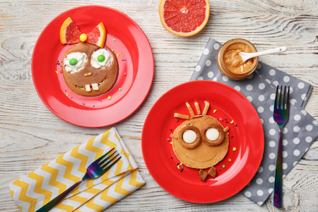 Funny pancakes for kids breakfast on wooden table, top viewの写真素材