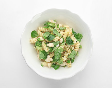 Tasty pasta salad with fresh herbs on white backgroundの写真素材