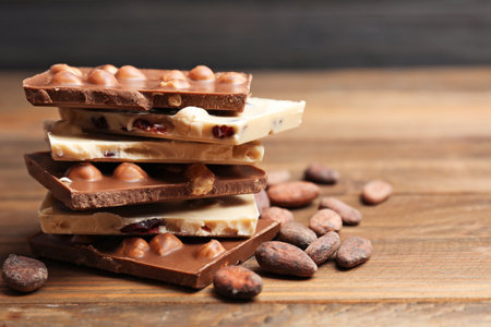 Yummy chocolate pieces with hazelnuts on wooden tableの写真素材