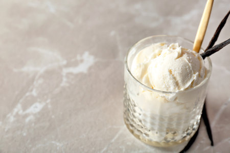Glass with tasty vanilla ice cream on light backgroundの写真素材