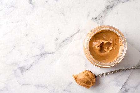 Jar with creamy peanut butter on light backgroundの写真素材