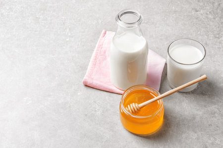 Beautiful composition with milk and honey on gray backgroundの写真素材