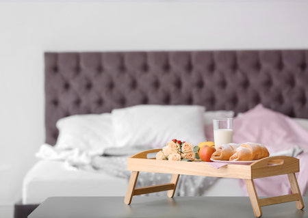 Tray with delicious croissants, milk and apples on tableの写真素材