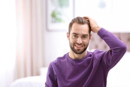 Portrait of young man with beautiful hair indoorsの写真素材