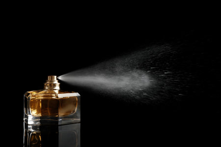 Spray bottle of perfume on black backgroundの写真素材