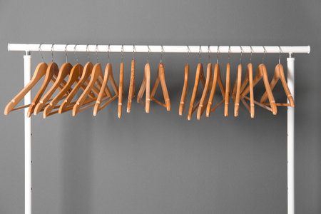 Clothes rail with wooden hangers on gray backgroundの写真素材