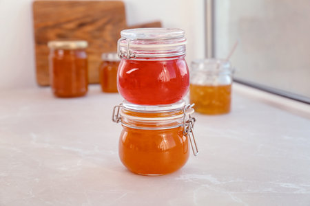 Jars with different sweet jam on windowsill