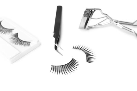 False eyelashes, tweezers and curler on white backgroundの写真素材