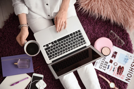 Female blogger with laptop and cup of coffee indoors, top viewの写真素材