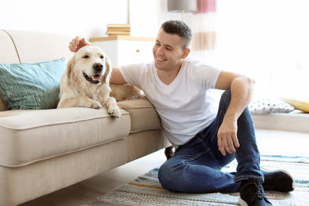 Portrait of owner with his friendly dog at homeの写真素材