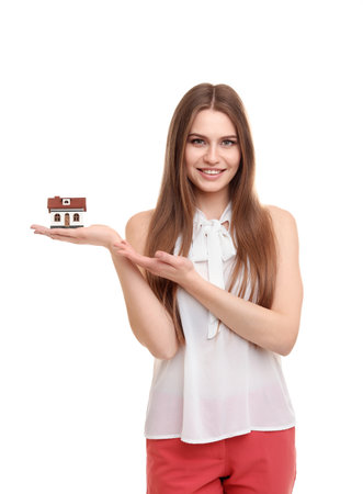 Beautiful real estate agent with house model on white backgroundの写真素材