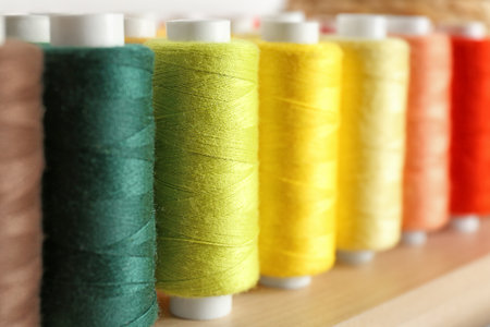 Set of color sewing threads on wooden shelfの写真素材