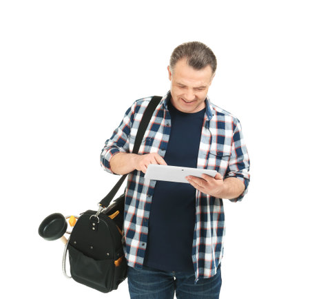 Mature plumber with tablet computer and tool bag on white backgroundの写真素材