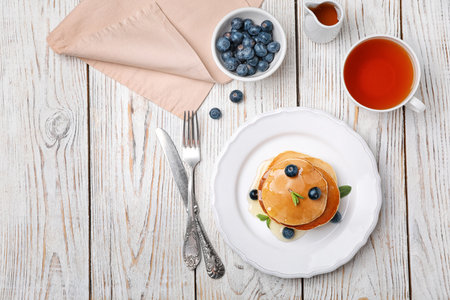 Flat lay composition with tasty pancakes and cup of tea on wooden backgroundの写真素材
