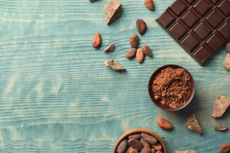 Flat lay composition with cocoa powder and chocolate bar on wooden backgroundの写真素材