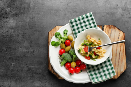 Tasty pasta salad with vegetables on tableの写真素材