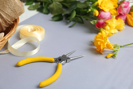 Florist workplace with pliers and flowers on tableの写真素材