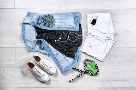 Set of trendy female clothes and accessories on wooden background, flat lay