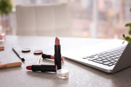 Makeup products for woman and laptop on tableの写真素材