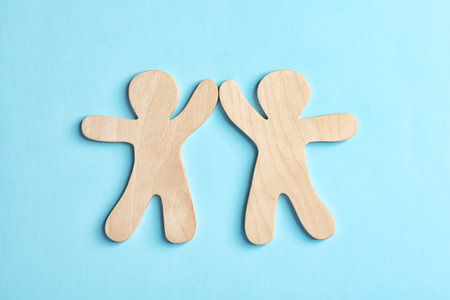 Wooden people giving high five on color background. unity concept