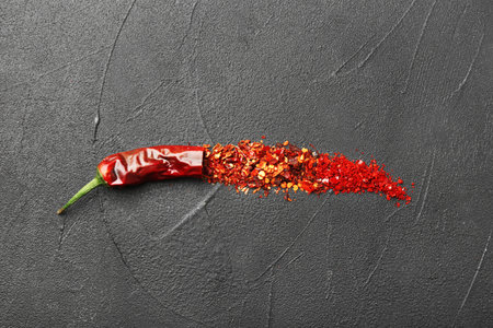 Composition with chili pepper flakes on gray background, top viewの写真素材