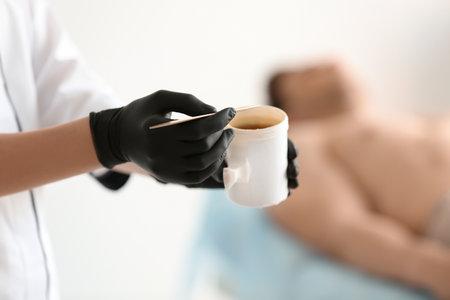 Female beautician with wax for epilation in salonの写真素材