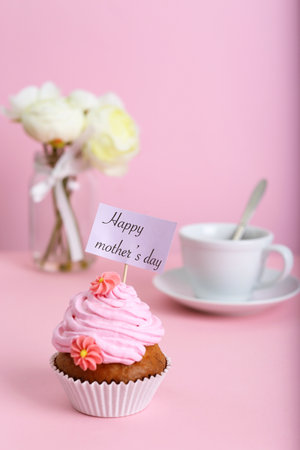 Topper with words HAPPY MOTHER'S DAY in cupcake on tableの写真素材