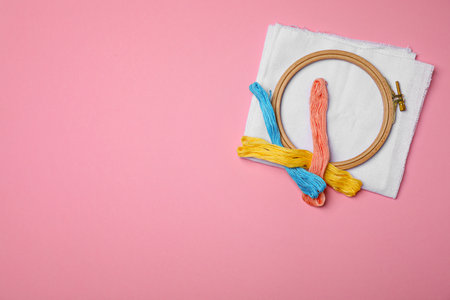 Sewing threads, fabric and hoop on color backgroundの写真素材