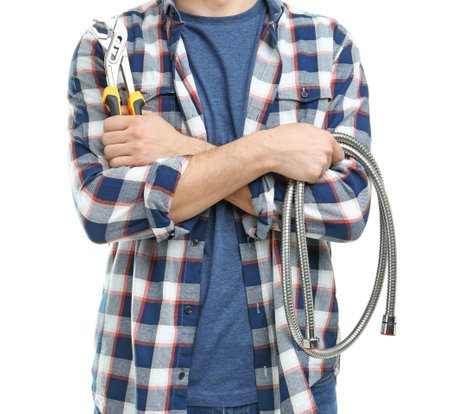 Young plumber with hose and adjustable wrench on white backgroundの写真素材
