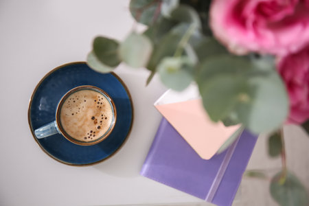 Cup of coffee and flowers on table, top viewの写真素材