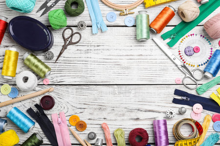 Composition with color threads and sewing accessories on wooden background, top view