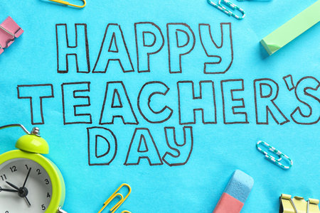 Alarm clock, text HAPPY TEACHER'S DAY and stationery on color paperの写真素材