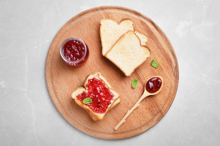 Toasts with jam on wooden board, top view