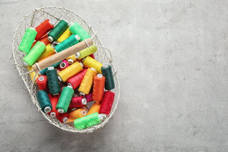 Metal basket with color sewing threads on gray background, top viewの写真素材