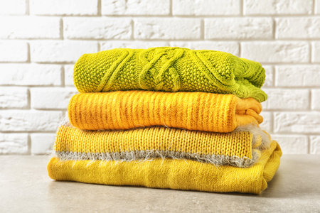 Stack of warm knitted clothes on tableの写真素材