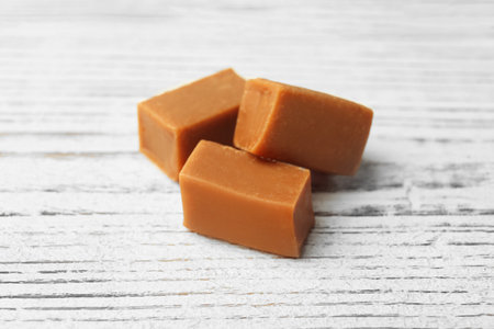 Delicious caramel candies on wooden background