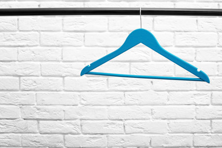 Clothes hanger on metal rail against brick wall backgroundの写真素材